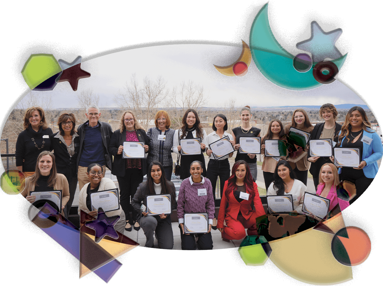 A cohort of Empowering Women in Business participants stand in two rows on a rooftop at CU Denver. They are holding their program participation certificates and smiling proudly.